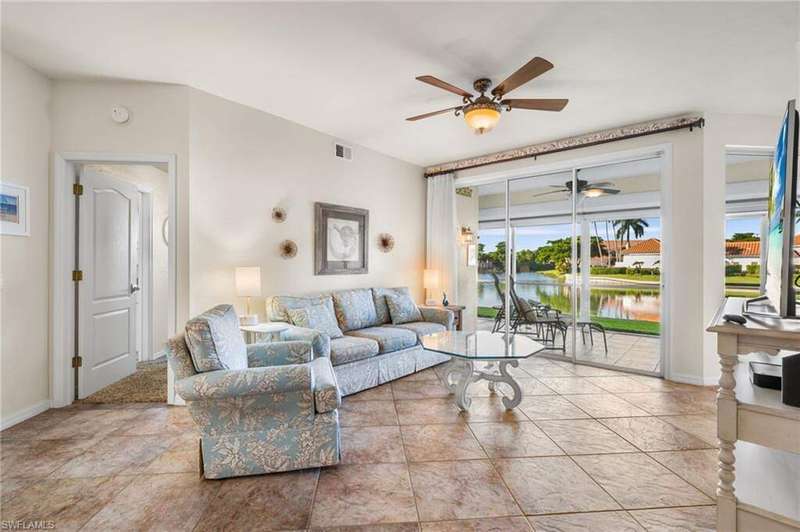Living room featuring ceiling fan and a water view