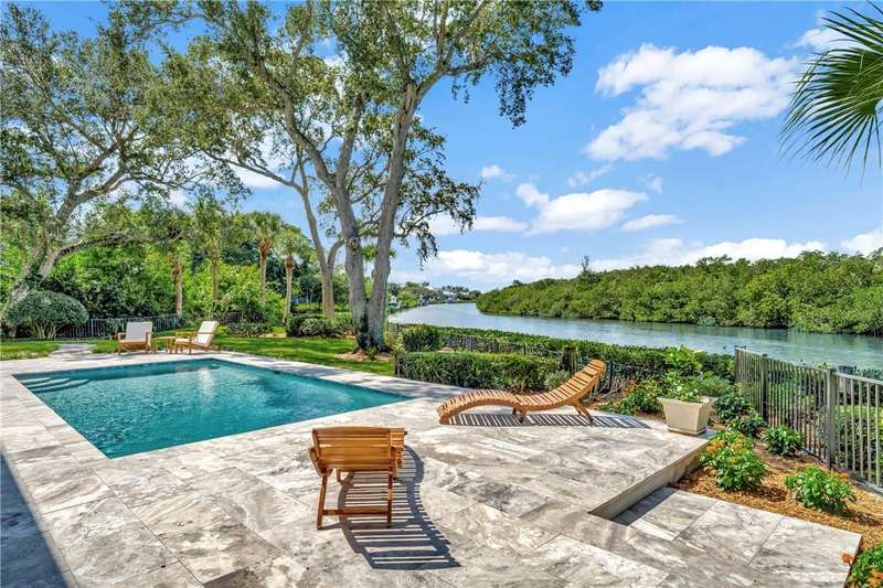 Aerial view of a nearby body of water and a pool a