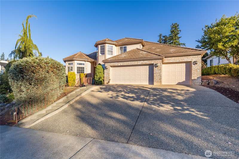 The home has a commanding presence above the street.  It's a 5 bedroom home, with one primary bedroom on the first floor, and another primary bedroom upstairs, and it has a 3 car garage