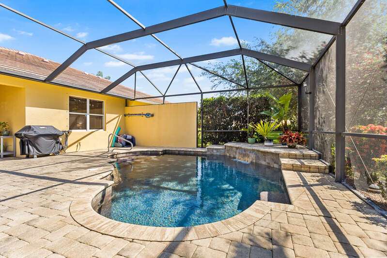 Outdoor pool featuring a water view, a patio area, and a lanai