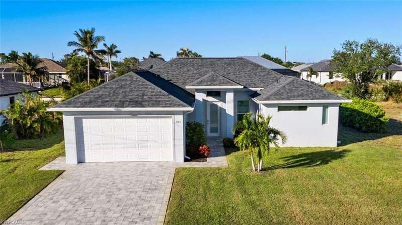 View of front facade with a garage and a front lawn