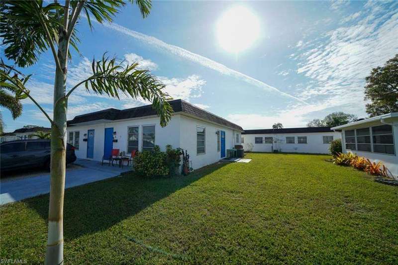 Back of property with a lawn, a patio area, and central AC unit