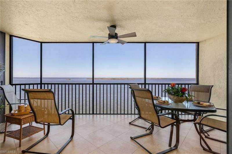 Sunroom / solarium featuring a water view and ceiling fan