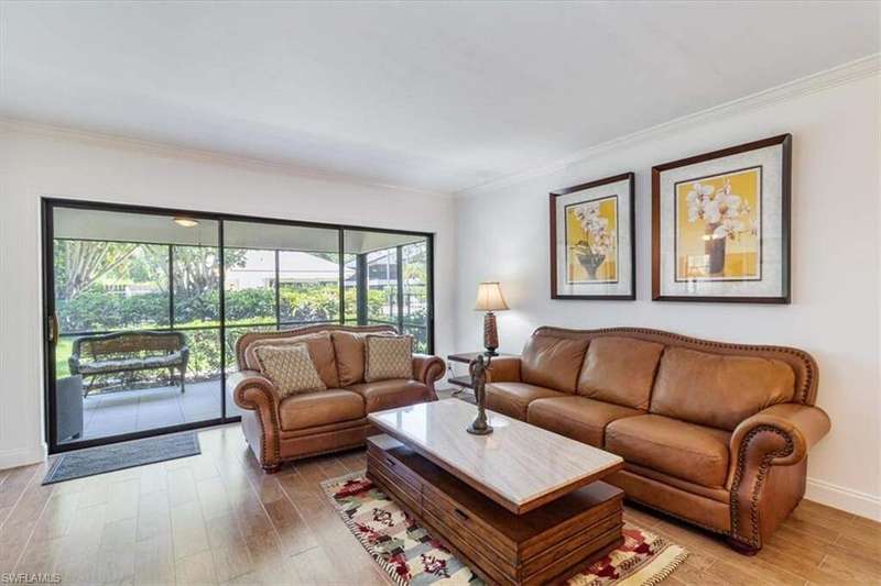 Living room with tile wood-like flooring and ornamental molding