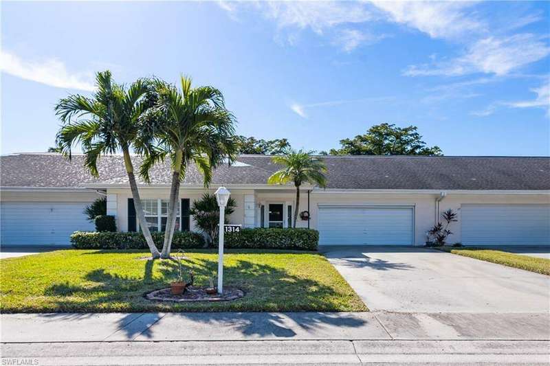 Single story home with a garage and a front lawn