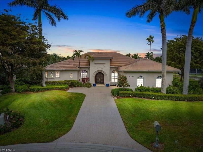 Mediterranean / spanish home featuring stucco siding, a front lawn, a tiled roof, and decorative driveway
