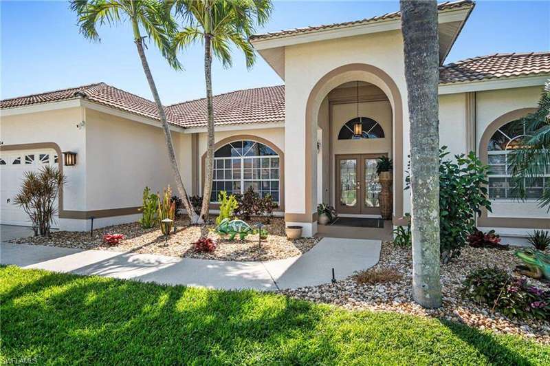 Entrance to property with a garage, stucco siding, a tile roof, and french doors