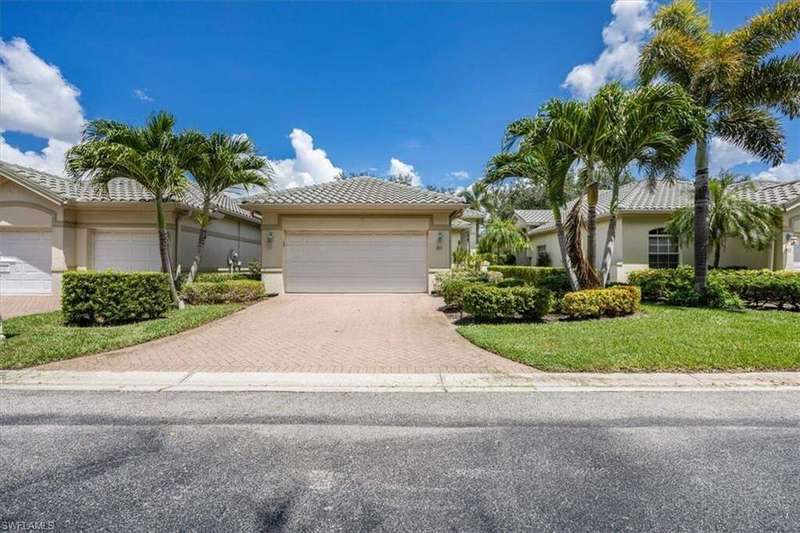 Ranch-style house featuring decorative driveway, stucco siding, a garage, a tile roof, and a front yard