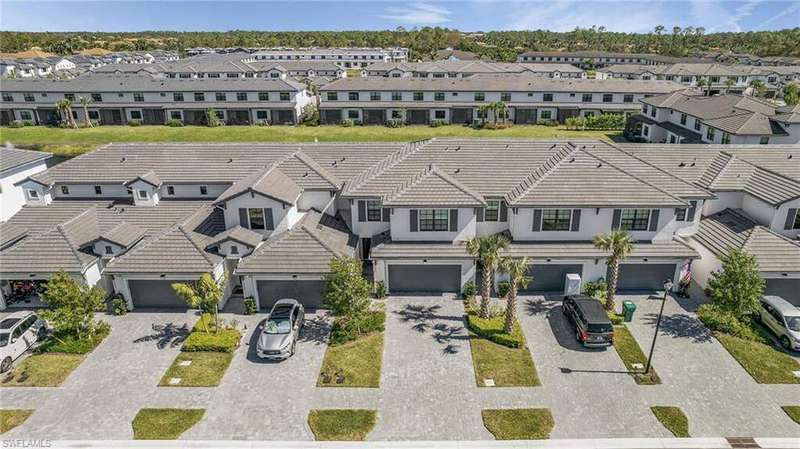 View of front of home with a tiled roof, an attached garage, stucco siding, and decorative driveway