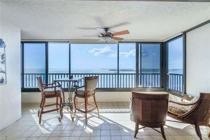 Sunroom / solarium with a water view, a healthy amount of sunlight, and ceiling fan