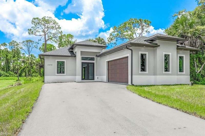 Prairie-style home with a garage and a front lawn