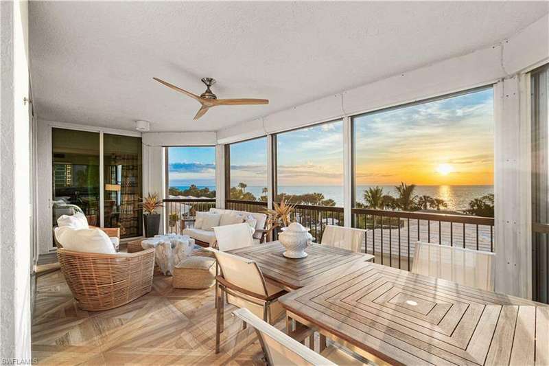 Sunroom / solarium featuring ceiling fan and a water view