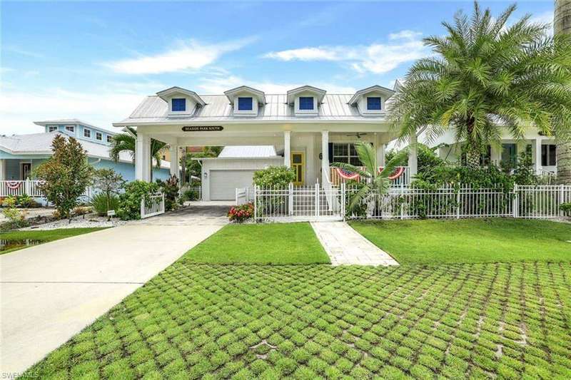 View of front of 158 Jeepers Drive with expansive covered porch, porte cochere-covered driveway, and a front yard.