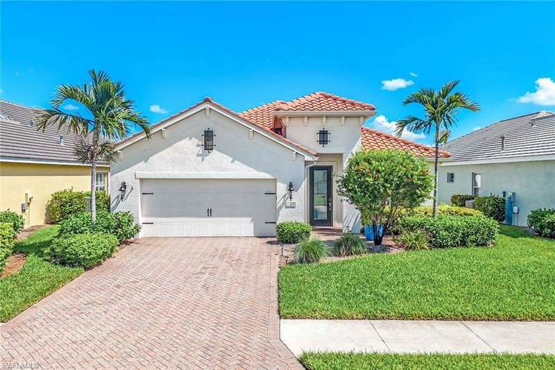 Mediterranean / spanish house featuring a front lawn and a garage