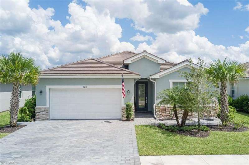 Single story home with stone siding, stucco siding, decorative driveway, an attached garage, and a tiled roof