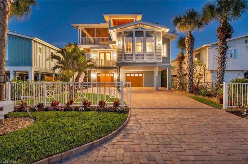 View of front facade featuring decorative driveway, a balcony, and an attached garage