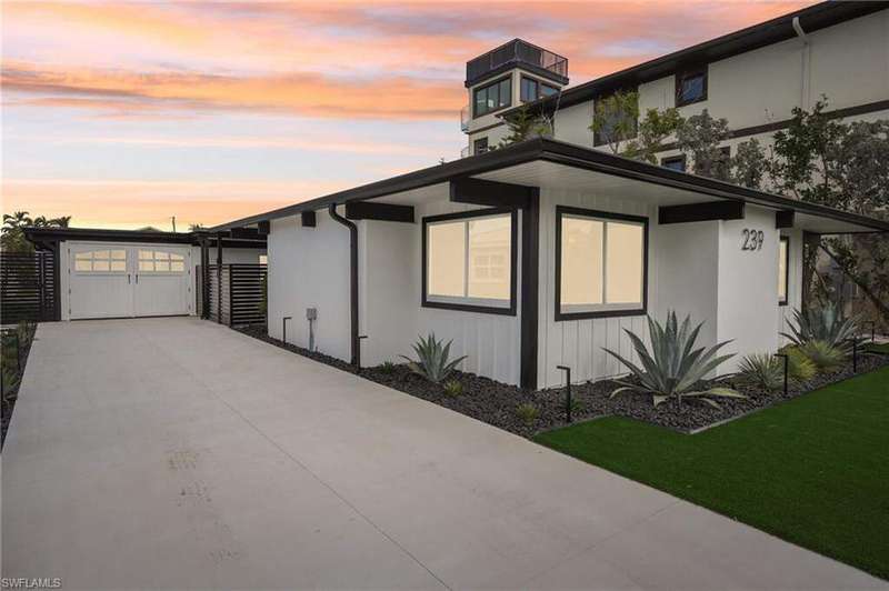 Property exterior at dusk featuring stucco siding, an attached garage, and concrete driveway