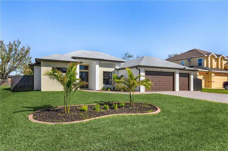 Prairie-style house with a front lawn, fence, stucco siding, and an attached garage