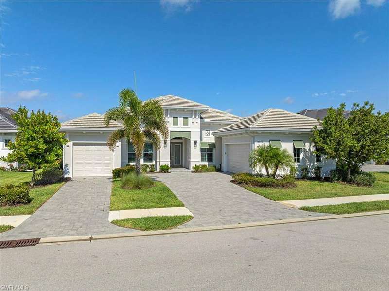 View of front of property featuring a garage and a front lawn