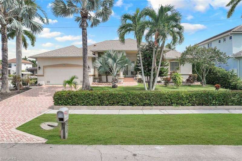 View of front of property with a garage and a front lawn