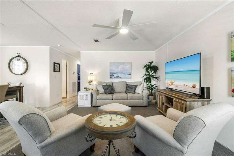 Living room with ornamental molding, ceiling fan, and hardwood / wood-style flooring