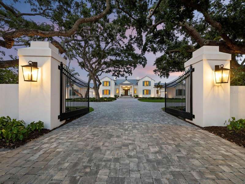 Elegant front entry through a gated motor court graced by Live Oak trees to the impressive residence .