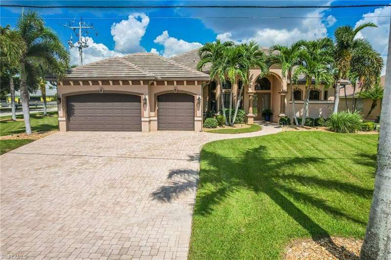 Mediterranean / spanish home featuring a garage and a front lawn