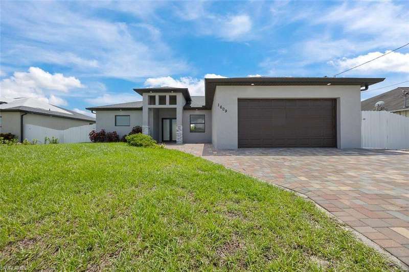 Prairie-style house featuring stucco siding, an attached garage, and decorative driveway