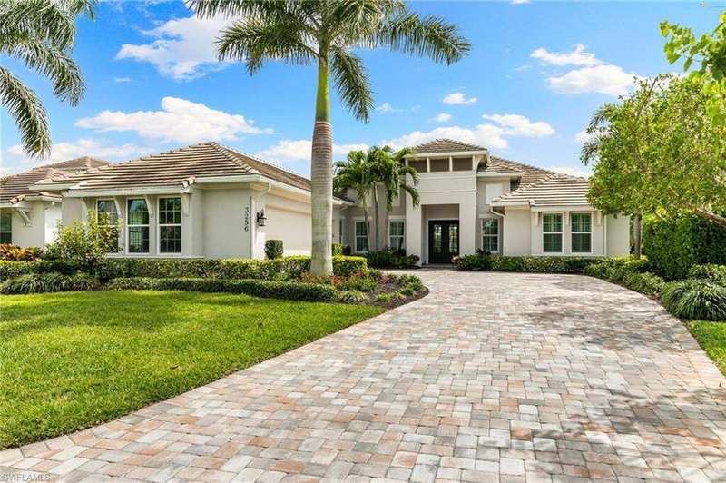 Mediterranean / spanish-style house with stucco siding, a front lawn, french doors, a tile roof, and decorative driveway