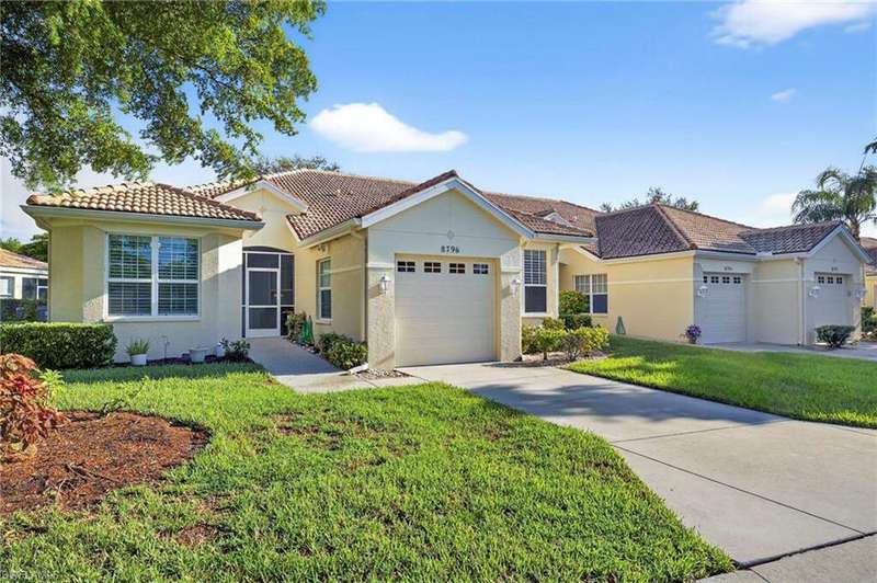 Mediterranean / spanish-style house with stucco siding, an attached garage, concrete driveway, and a front lawn
