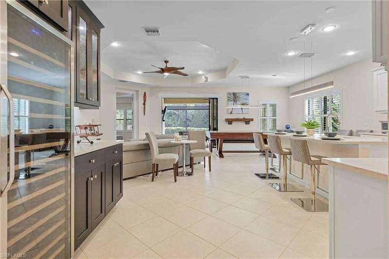 Kitchen with backsplash, light tile floors, sink, white cabinets, and appliances with stainless steel finishes