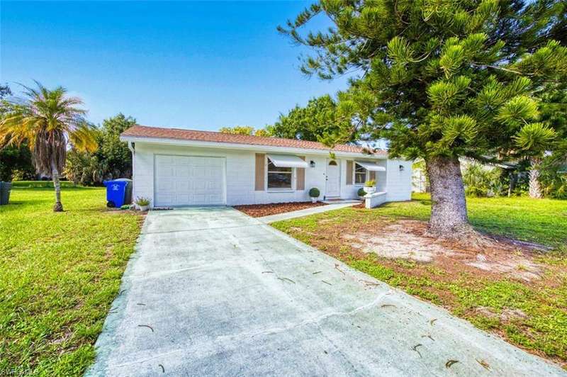 Single story home featuring a front yard, a garage, and driveway