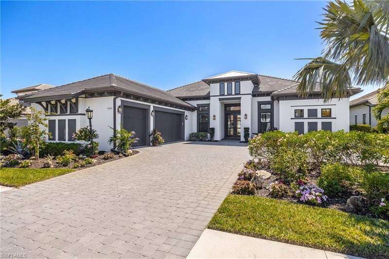 Prairie-style home with an attached garage, stucco siding, french doors, a tiled roof, and decorative driveway