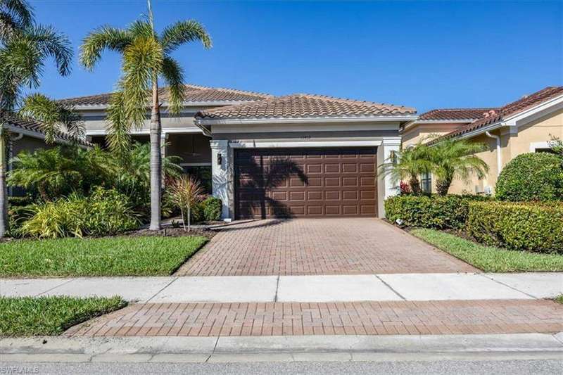 View of front of house featuring decorative driveway, a tiled roof, an attached garage, and stucco siding