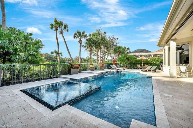 View of pool with pool water feature and a patio