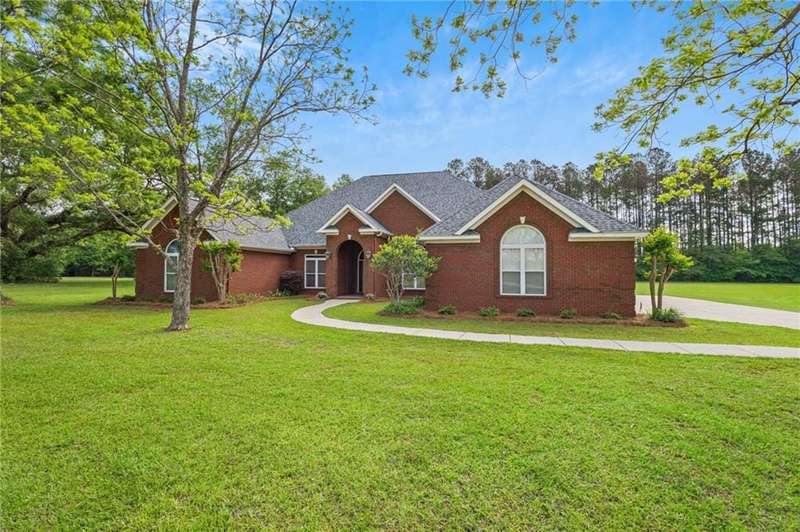 Single story home with brick siding, a shingled roof, and a front yard