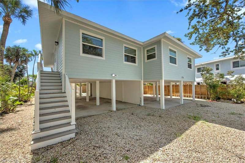 Rear view of property featuring a carport, stairs, a patio area, and driveway
