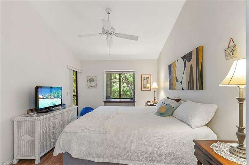 Bedroom with ceiling fan, vaulted ceiling, and hardwood / wood-style floors