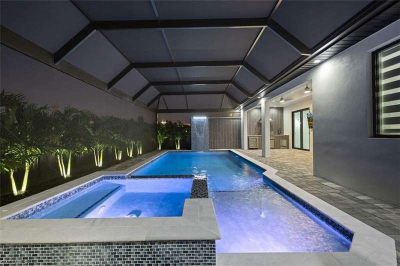 View of swimming pool featuring a patio area, a lanai, and an in ground hot tub