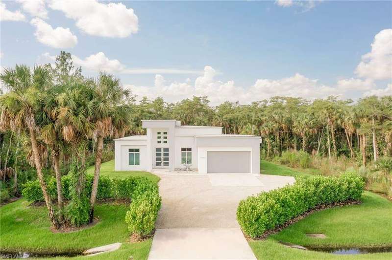 View of front facade with a garage and a front lawn