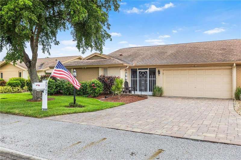 Single story home featuring decorative driveway, a garage, a front yard, roof with shingles, and stucco siding
