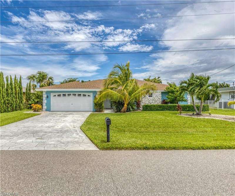 Single story home featuring a garage and a front yard