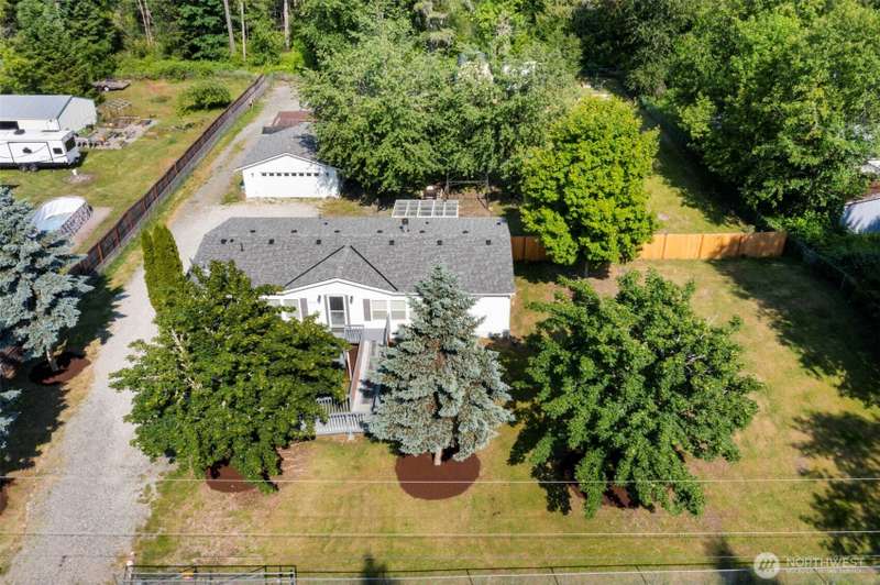Aerial shots showcase the upgraded roof, vibrant greenery, and secure, fully fenced yard.