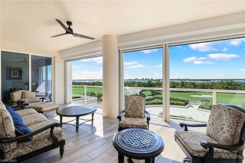 Tiled living room featuring ceiling fan and ornamental molding