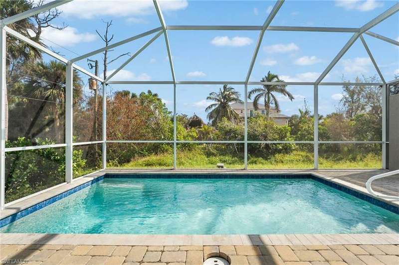 View of pool featuring a patio and glass enclosure