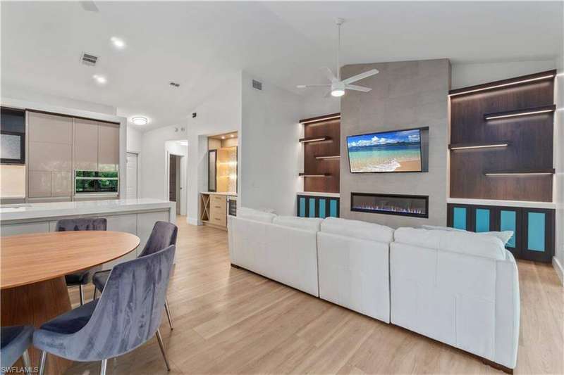 Kitchen featuring open shelves, modern cabinets, freestanding refrigerator, light wood-style flooring, and vaulted ceiling