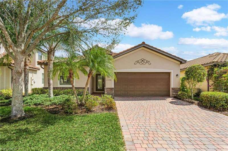 Mediterranean / spanish home with a garage, stone siding, a tiled roof, decorative driveway, and stucco siding