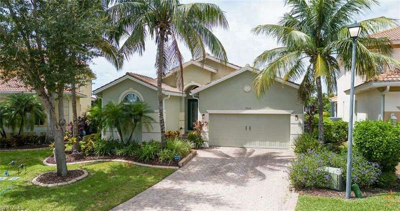 Mediterranean / spanish-style home with a garage and a front lawn