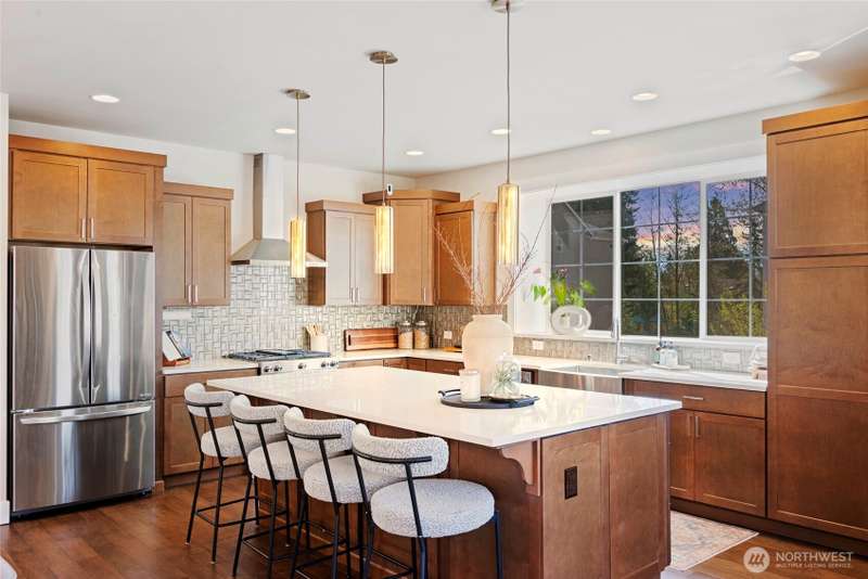 Welcome to this stunning home with a chef-inspired kitchen that has quartz countertops, a generous island, designer pendants, stainless steel appliances, rich cabinetry and a large window.