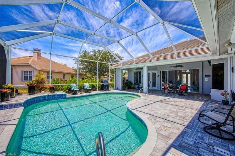 Outdoor pool featuring a sunroom, a lanai, a water view, a patio area, and french doors